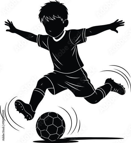 Silhouette of a young boy playing soccer kicking the ball with dynamic motion
