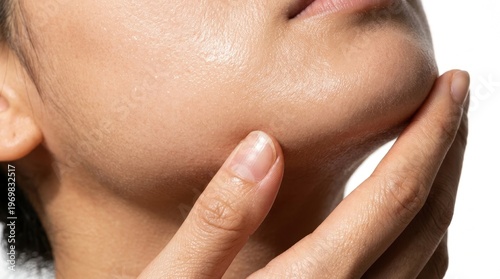 Close-up of a person's hand gently touching their clean, healthy, and hydrated skin on the chin, emphasizing a natural glow and the benefits of a good skincare routine.