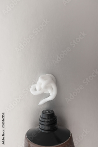 Minimal hand cream squeezed from tube on gray background. Skincare cream modern aesthetic