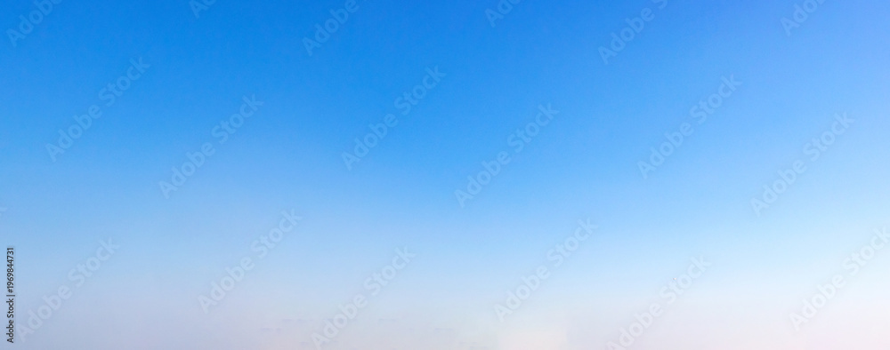 Obraz premium Clear gradient blue sky with subtle haze near horizon, minimal background pattern for design, presentation and wallpaper use.