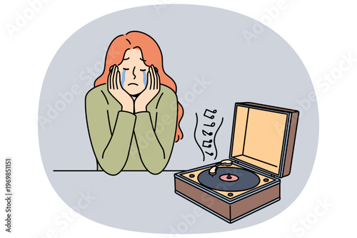 Woman cries listening to music on vinyl player, due to nostalgia and memories of happy past. Girl experiences nostalgia after launching retro device with audio album from last century