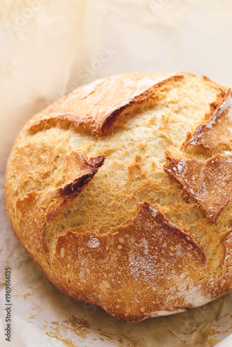 Round sourdough loaf resting on black wire cooling rack with beige linen towel. Perfect for baking, food blogs, and culinary projects