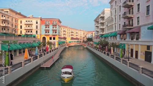 Doha, Qatar - 20th january, 2026: Picturesque canals of Qanat Quartier at The Pearl-Qatar, Doha. Venetian-inspired architecture with pastel buildings, arched bridges, and a motorboat on the water