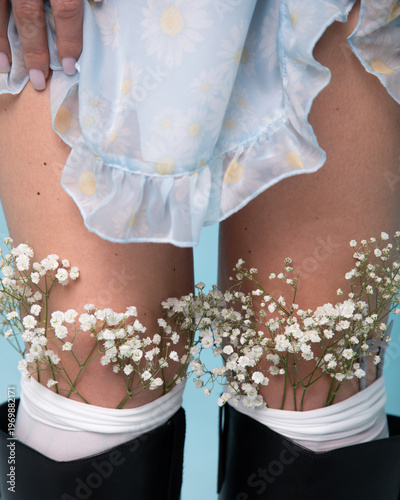 Woman in blue dress with gypsophila flowers in socks close up studio