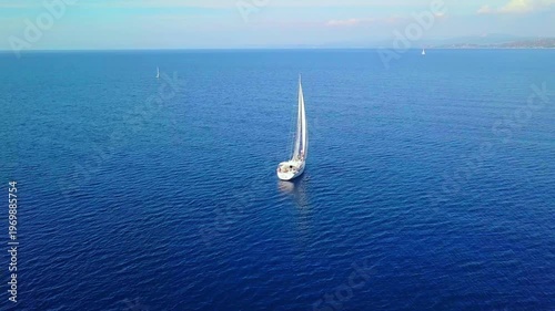 A Serene Sailing Adventure: A Beautiful Yacht Gliding Through the Tranquil Blue Waters in Greece