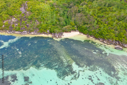 Bird eye drone of cap ternay beach, white sands, transparant water, granites rocks and forest, Mahe, Seychelles 