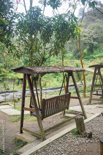 Wallpaper Mural Wooden swing in a nature tourism area with a green forest background and relaxing atmosphere. Torontodigital.ca