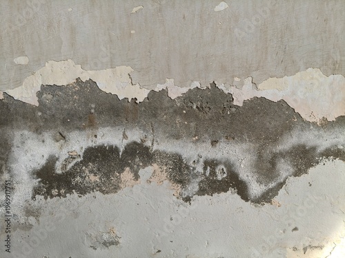 Close-up of a Severely Damaged Wall with Peeling Paint and Exposed Dark Concrete Layers