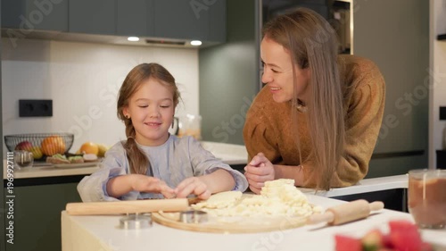 Mother and daughter spending quality time baking cookies in a modern kitchen