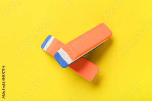 Rubber erasers on yellow ba...
