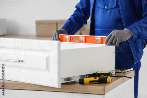 Male worker with level asse...