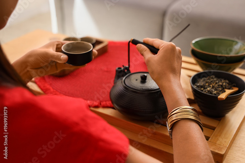 Young Asian woman pouring t...
