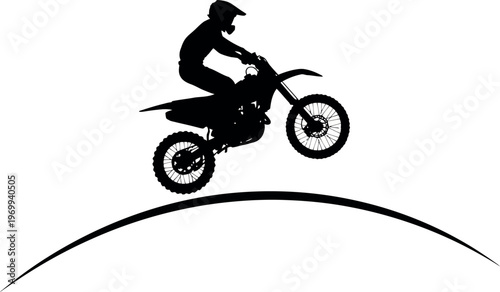 Silhouette of a person riding a motorcycle over a jump