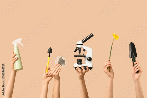Female hands with modern microscope, gardening shovels, water sprayer, daffod...