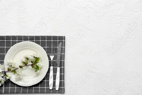 Beautiful table setting with blooming branch on white background