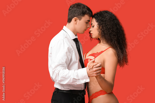 Sexy young couple on red ba...