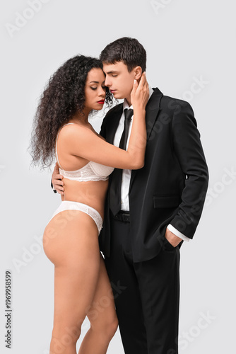 Sexy young couple on grey b...