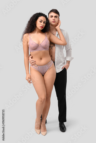 Sexy young couple on grey b...