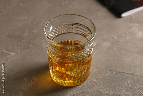 Glass of cold rum on grey b...