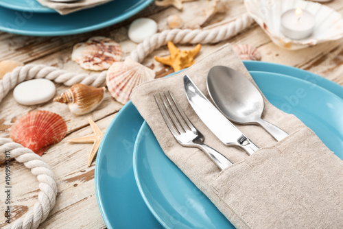 Beautiful table setting with marine decor on light wooden background