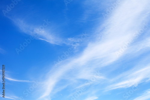 Beautiful sky landscape of cirrus clouds in a blue sky. Light cloud cover before the weather changes. Natural background of different shades of blue color. Empty space for text or abstract design