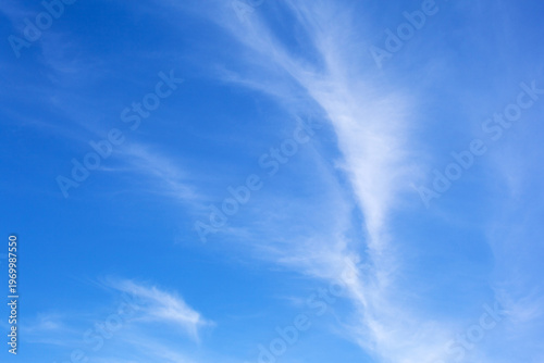 Cirrus clouds in a blue sky. Light cloud cover before the weather changes. Beautiful sky landscape. Natural background of different shades of blue color