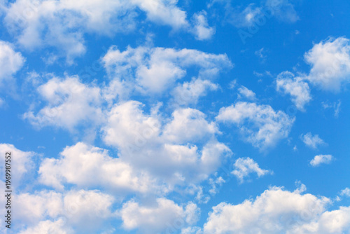 Cumulus clouds in sunny blue sky. Light cloud cover on nice weather. Beautiful sky landscape. Natural background of different shades of blue color
