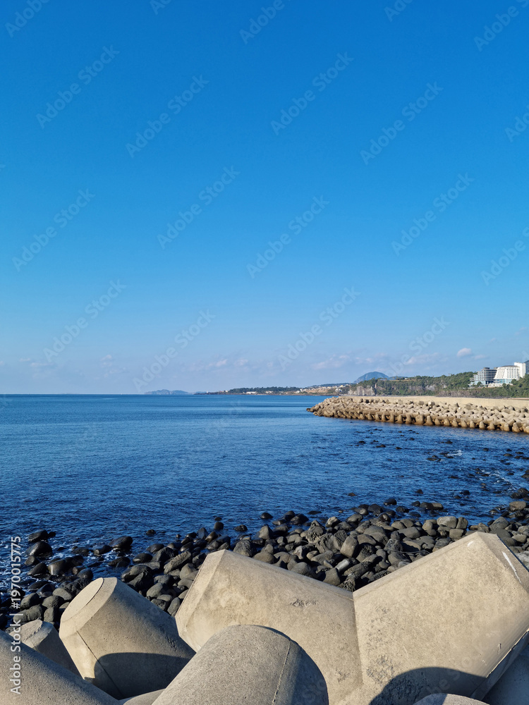 Fototapeta premium The blue Jeju sea with a breakwater.