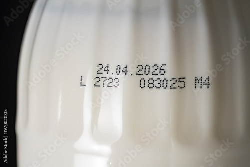 Canvas Print Closeup of an expiration date and batch code printed on white plastic bottle with dairy product