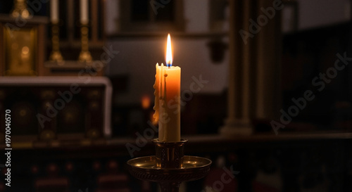 Lit candle on altar in dimly lit church interior  