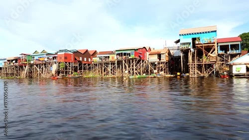 Wallpaper Mural A row of traditional wooden and corrugated metal houses built high on stilts stands along the lake Tonle Sap in Cambodia Torontodigital.ca