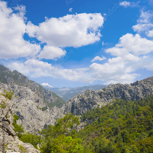 green mountain canyon under a blue cloudy sky