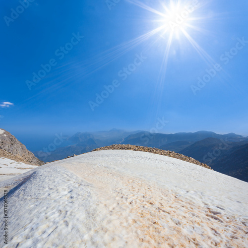 mountain ridge in a snow under a sparkle sun