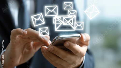Businessman's hands using smartphone with glowing email icons appearing