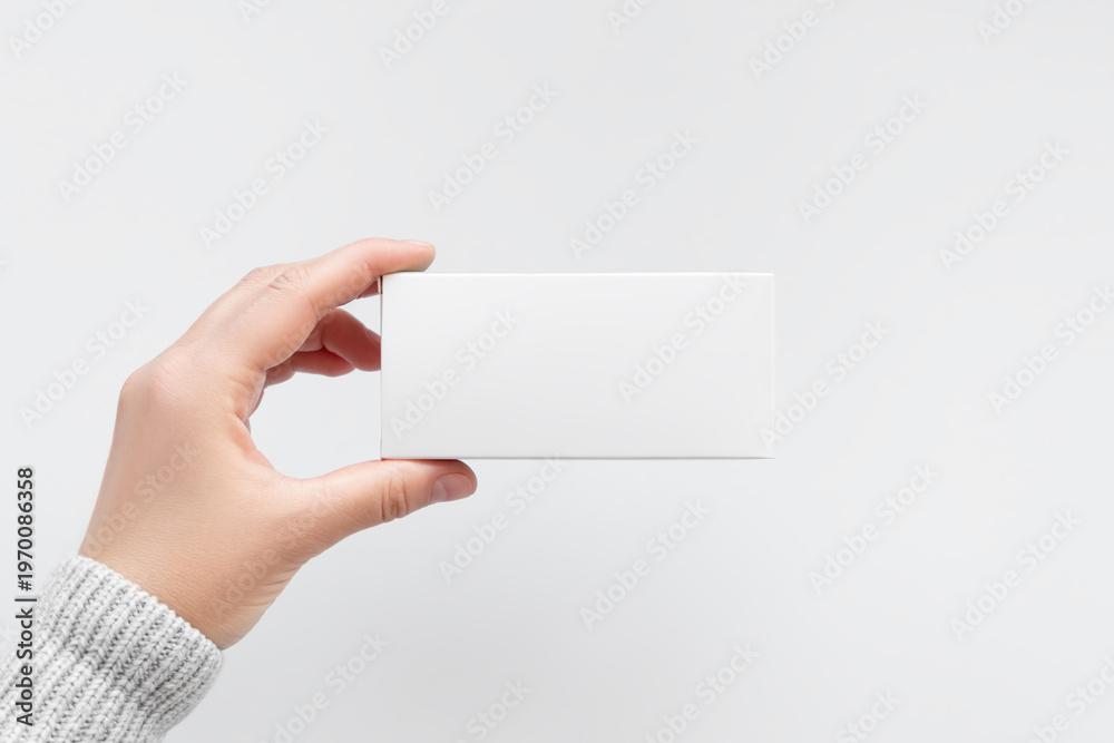 Obraz premium Hand Holding Blank White Square Cardboard Pill Box Mockup 