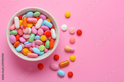 Colorful Assortment of Medical Pills and Capsules in a Bowl on Pink Background