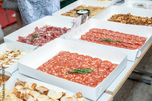 Gourmet Tapas Buffet with Assorted Meat, Cheese, and Bread in White Catering Boxes