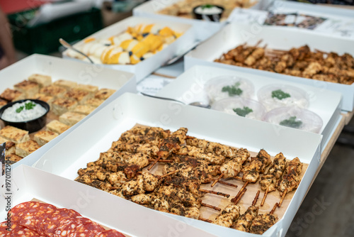 Gourmet Tapas Buffet with Assorted Meat, Cheese, and Bread in White Catering Boxes