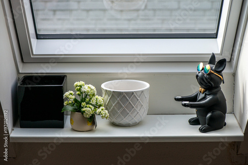 Stylish black dog figurine wearing round mirrored sunglasses