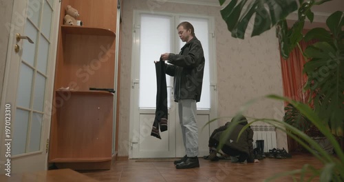 Man and child put on footwear winter shoes. 4K 10-bit