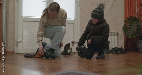 Man and child put on footwear winter shoes. 4K 10-bit