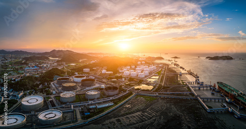 Panoramic view of oil storage tanks and petrochemical terminal at sunset. Energy infrastructure and industrial power concept.