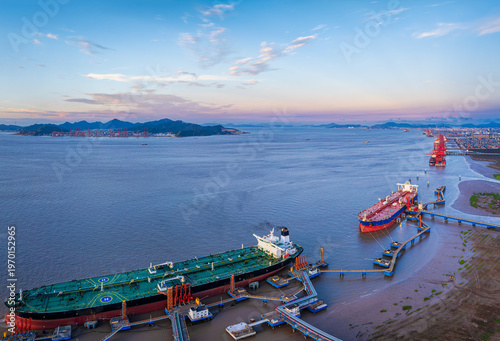 Bird's eye view of large oil tankers docked at terminal pier in calm sea. Global maritime transport and shipping logistics business.