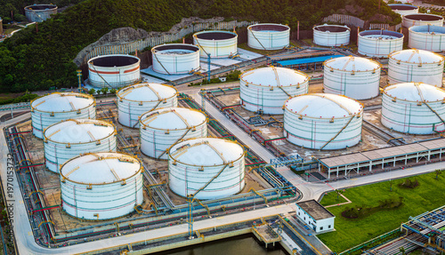 Aerial view of modern oil and gas storage tank farm facility with pipelines.