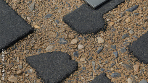 Close-up of asphalt shingle roof with gravel and damage