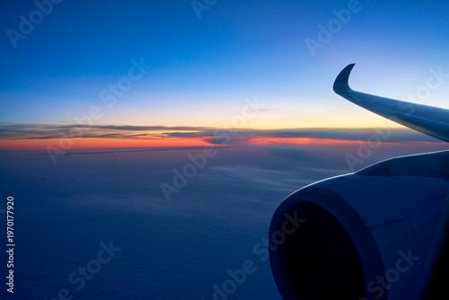 Serene high-altitude landscape above the clouds with an airliner wing, a metaphor for freedom and technological progress