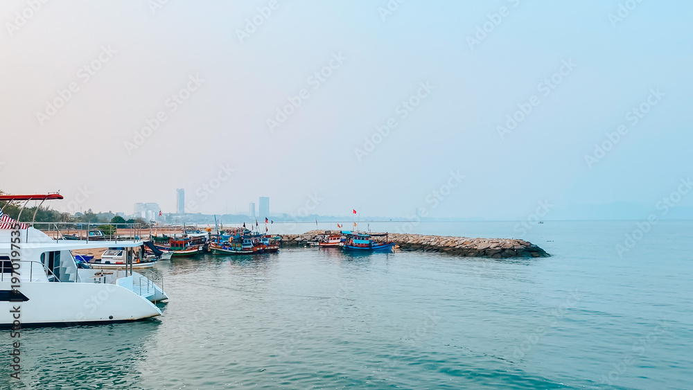 Fototapeta premium Scenic View of Harbor with Fishing Boats and City Skyline