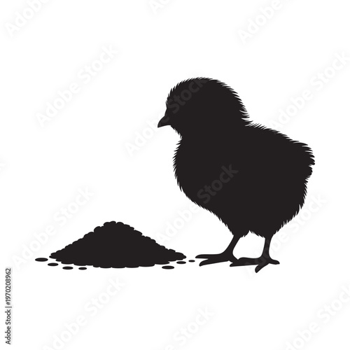 A silhouette of a fluffy chick foraging near a pile of feed