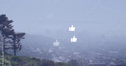 Floating white thumbs-up icons hovering over foggy neighborhood from hill, showing pine tree