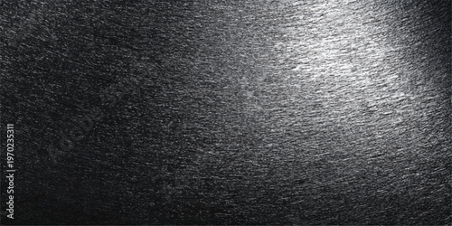 An abstract, dark, textured background. Emphasizing the subtle interplay of light and shadow, the image presents a tactile, intriguing surface.